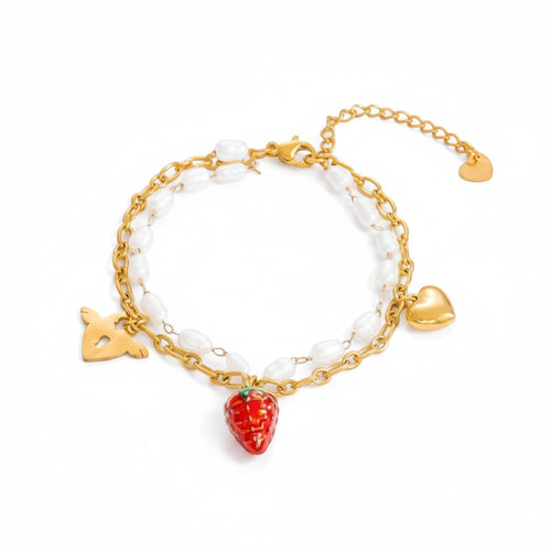 AM Charms Amourette bracelet with double gold chains, pearls, and strawberry, heart, and key charms. Gold plated stainless steel.